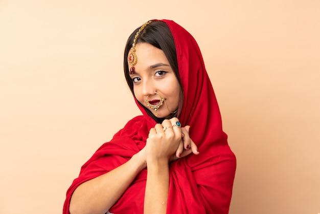 Young Indian woman on beige wall