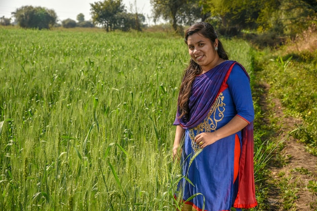 Una giovane lavoratrice agricola indiana che lavora nel campo dell'azienda agricola del grano.