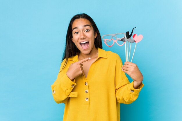 Young indian woman having fun and  holding a party objects isolated