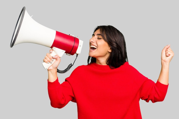 Young Indian woman holding a megaphone isolated