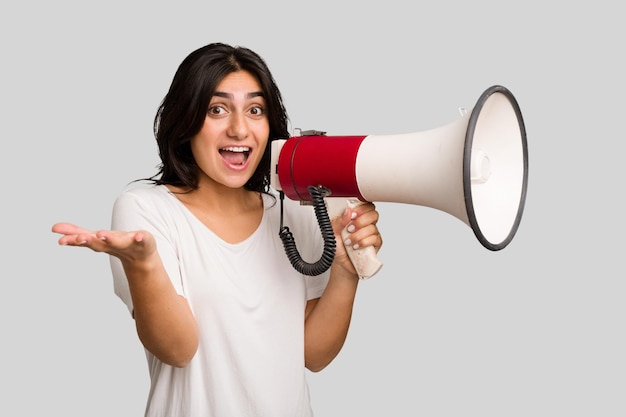 分離されたメガホンを保持している若いインド人女性