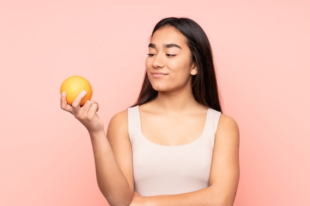 Young Indian woman holding an orange