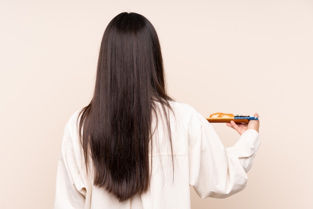 Young indian woman holding sushi over isolated