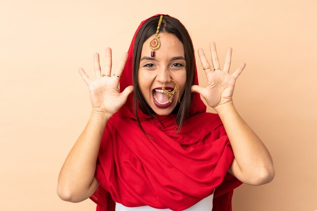 Photo young indian woman isolated on beige wall counting ten with fingers