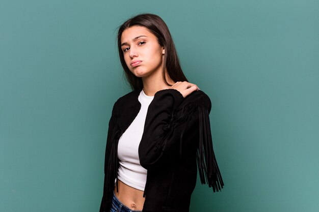 Young Indian woman isolated on blue wall having a shoulder pain.