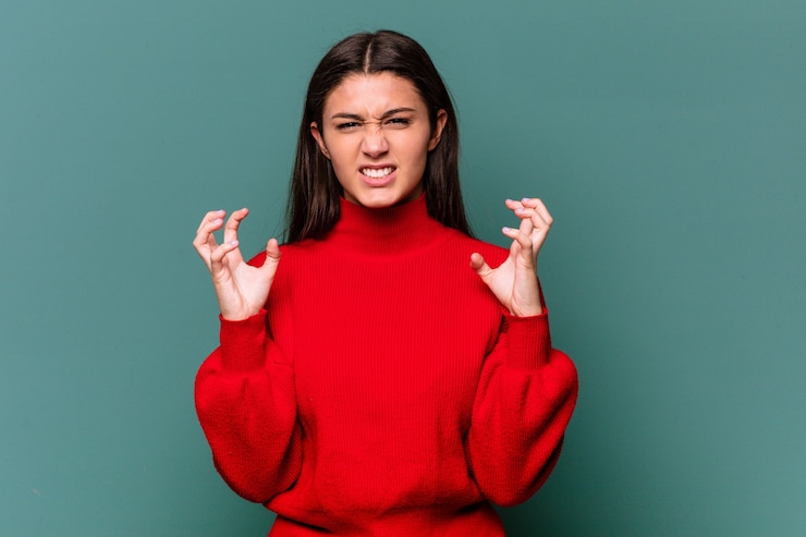 Photo young indian woman isolated on blue wall upset screaming with tense hands.