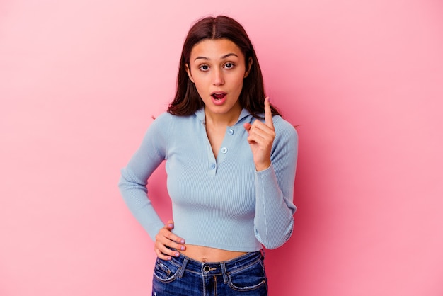 Young Indian woman isolated on pink having an idea, inspiration concept.