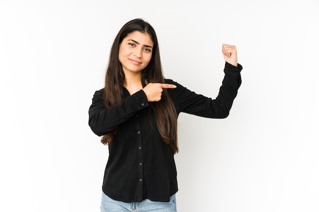 Young indian woman isolated on purple background showing strength gesture with arms, symbol of feminine power