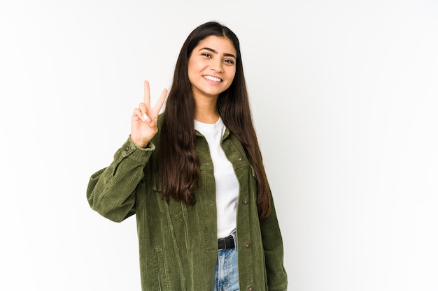 Young indian woman isolated on purple joyful and carefree showing a peace symbol with fingers.