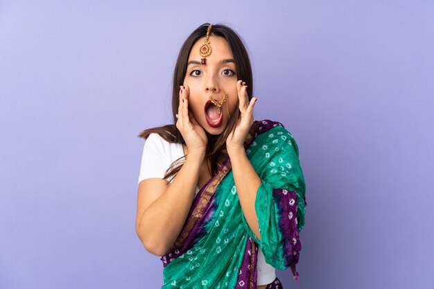 Young Indian woman isolated on purple space celebrating a victory in winner position