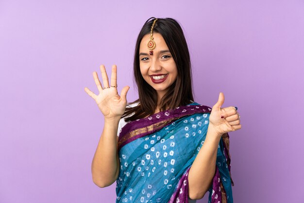 Young Indian woman isolated on purple wall counting six with fingers