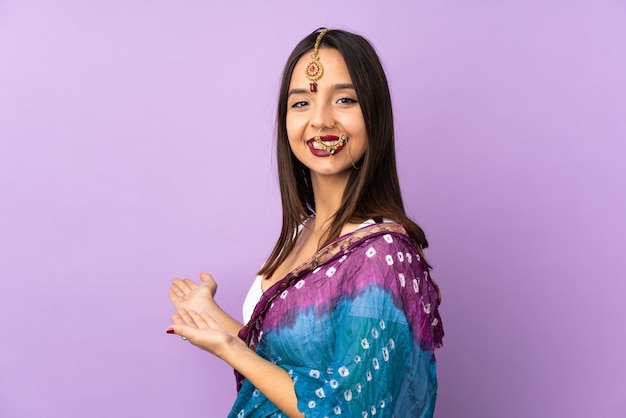 Young indian woman isolated on purple