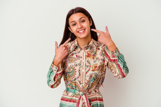 Young Indian woman isolated on white background smiles, pointing fingers at mouth.