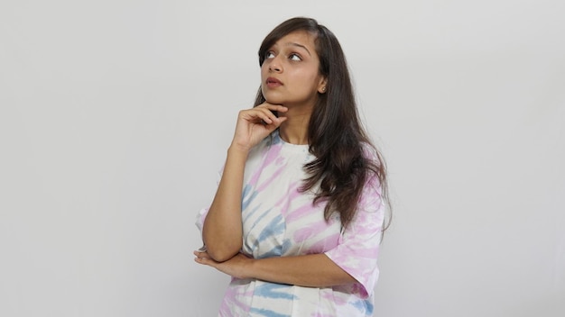 Young Indian woman looking opposite side on grey background