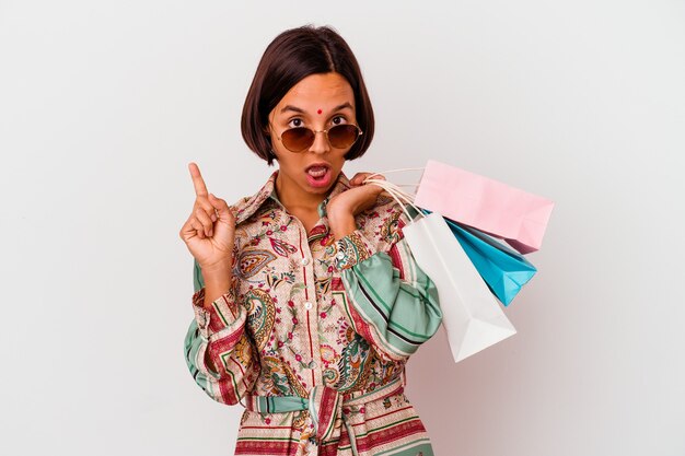 Young Indian woman shopping some clothes isolated on white background having some great idea, concept of creativity.