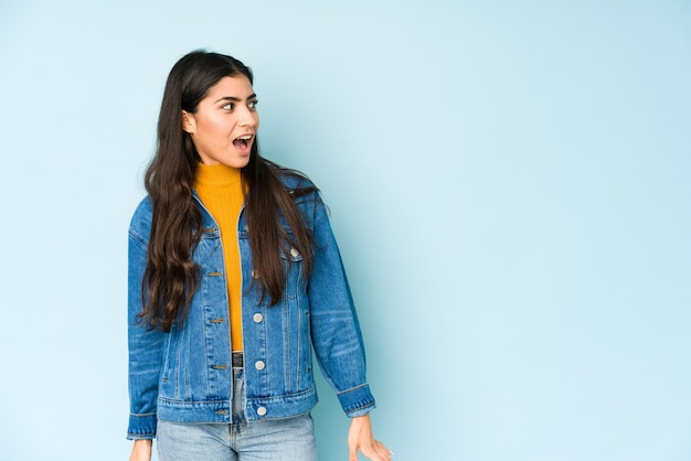 Young indian woman shouting very angry, rage concept, frustrated.