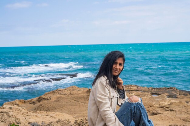 Foto giovane donna indiana seduta tra le rocce