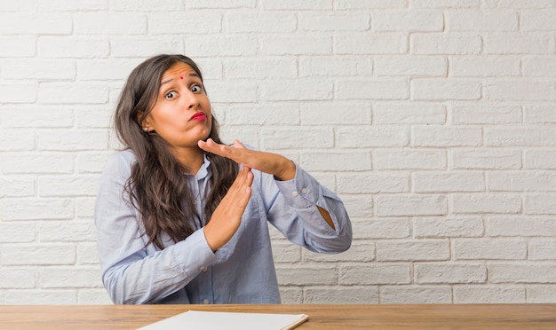 Young indian woman tired and bored, making a timeout gesture, needs to stop because of work stress