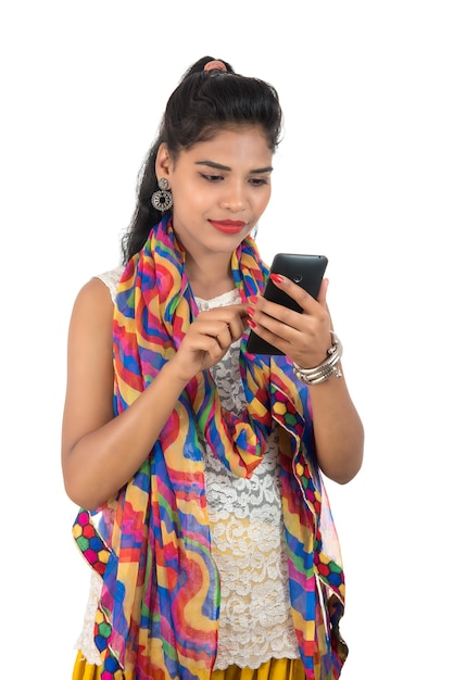 Young Indian woman using a mobile phone or smartphone isolated on white