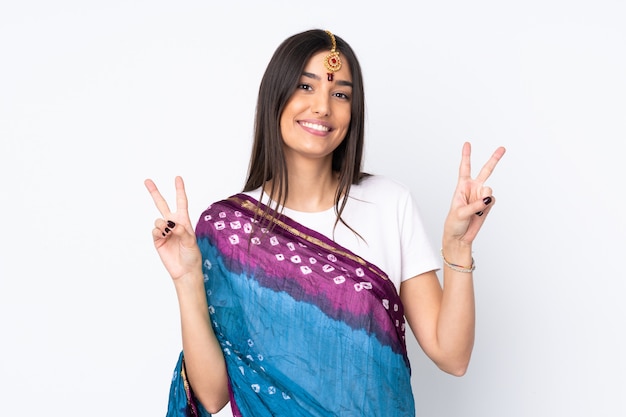 Young Indian woman on white showing victory sign with both hands