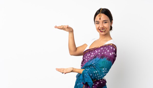 Young indian woman on white wall holding blank space