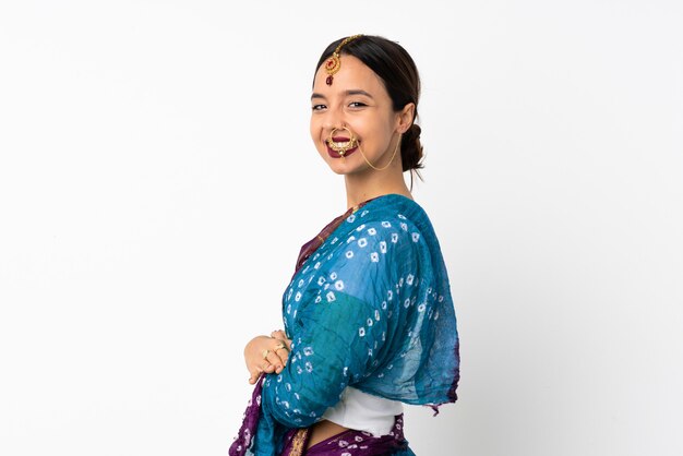 Young indian woman on white wall with arms crossed and looking forward