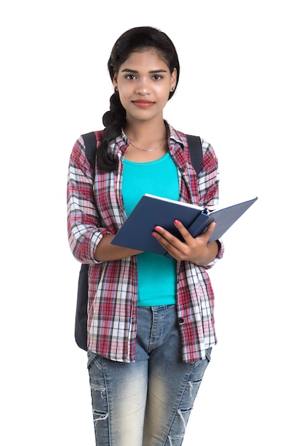 Photo young indian woman with backpack standing and holding notebooks, posing on a white wall.