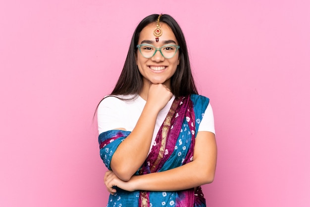 Young Indian woman with sari over isolated background with glasses and smiling