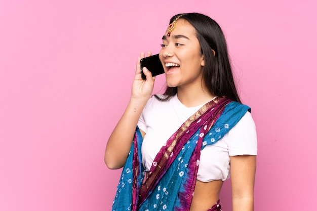 Young Indian woman with sari keeping a conversation with the mobile phone