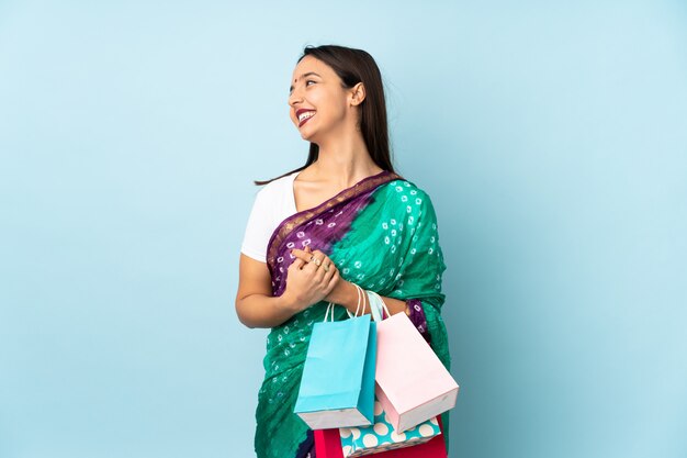 Young Indian woman with shopping bags happy and smiling