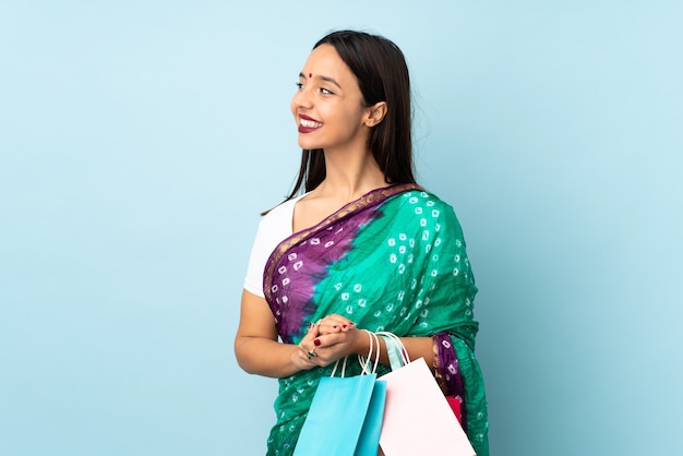 Young Indian woman with shopping bags looking side