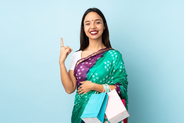 좋은 아이디어를 가리키는 쇼핑백과 젊은 인도 여자