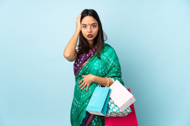 欲求不満の表現と理解していない買い物袋を持つ若いインド人女性
