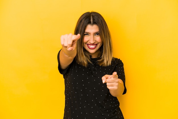 Young indian woman on yellow pointing to front with fingers