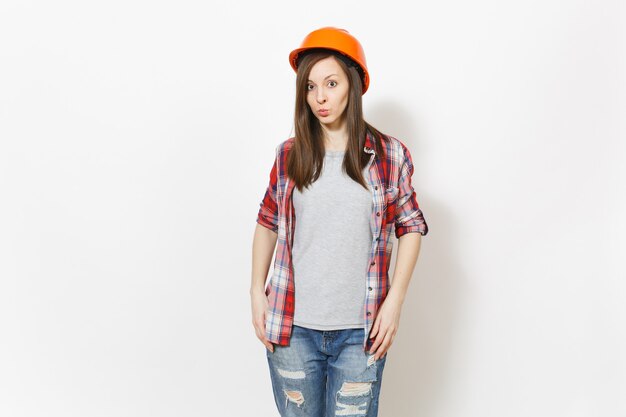 Young indifferent beautiful woman in casual clothes and protective construction orange helmet isolated on white background. Instruments, accessories for renovation apartment room. Repair home concept.