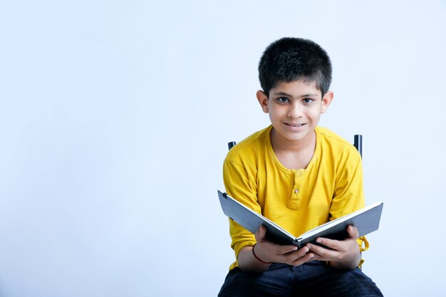 ノートを保持している若いインドの少年