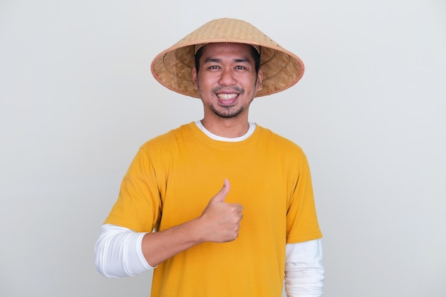 Young Indonesian farmer smiling at camera and give thumb up