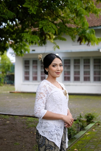 A young Indonesian woman with a happy successful expression wearing a white kebaya Kartini39s Day Concept