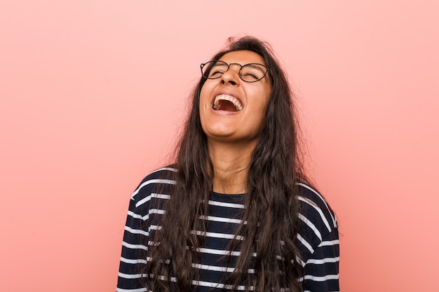 Young intellectual indian woman relaxed and happy laughing, neck stretched showing teeth.