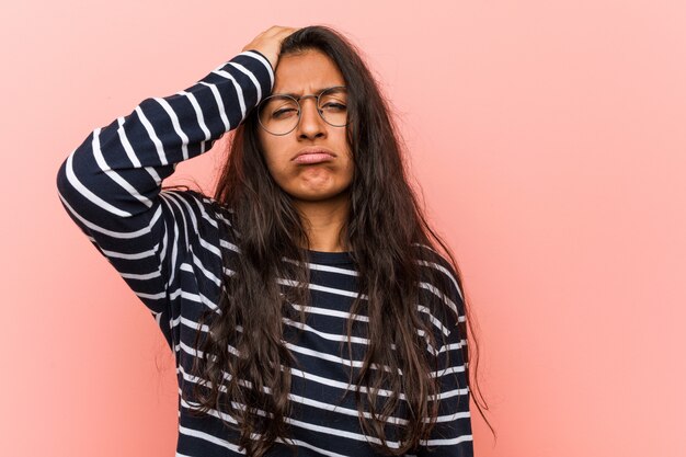 Young intellectual indian woman tired and very sleepy keeping hand on his head.