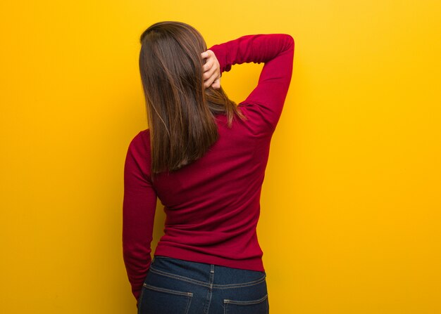 Young intellectual woman from behind thinking about something