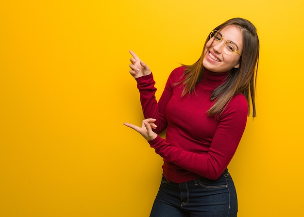 Young intellectual woman pointing to the side with finger