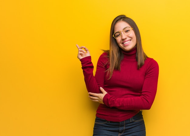 Young intellectual woman pointing to the side with finger