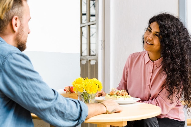 Photo young interracial couple eating in a restaurant.