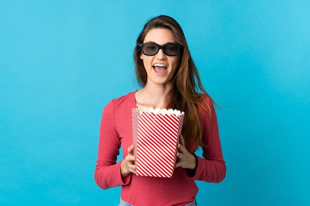 Young Ireland woman isolated with 3d glasses and holding a big bucket of popcorns