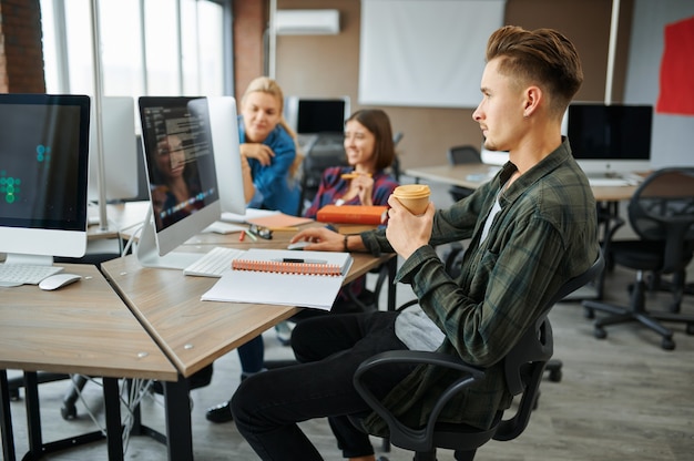 Photo young it specialists works on computers in office. web programmer or designer at workplace, creative occupation. modern information technology, corporate team