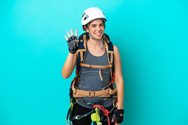 파란색 배경에 격리된 젊은 이탈리아 암벽 등반가 여성은 행복하고 손가락으로 4를 세고 있습니다.