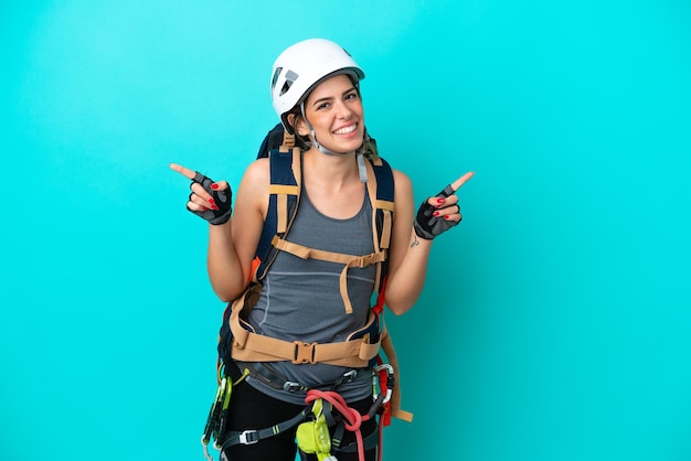 Young Italian rockclimber woman isolated on blue background pointing finger to the laterals and happy