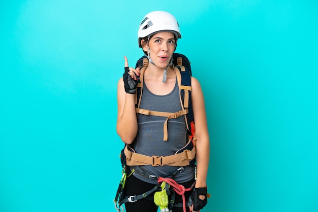 Young Italian rockclimber woman isolated on blue background thinking an idea pointing the finger up