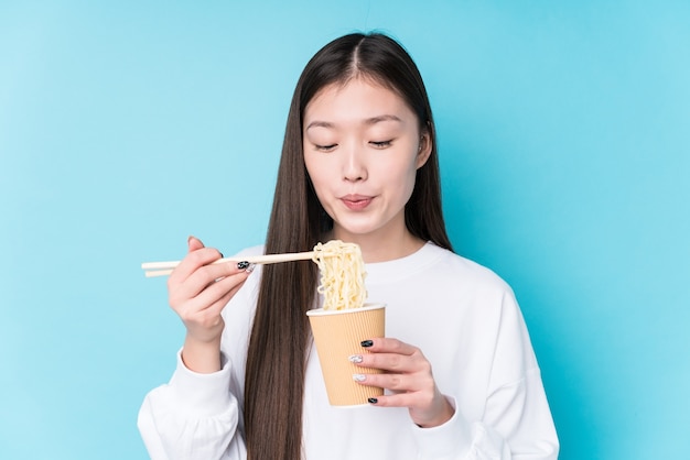 Молодая японская женщина ест лапшу